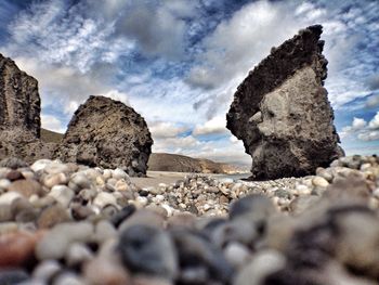 Scenic view of rocky beach against cloudy sky