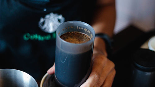 Close-up of hand holding coffee cup