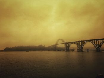 Bridge over river against sky during sunset