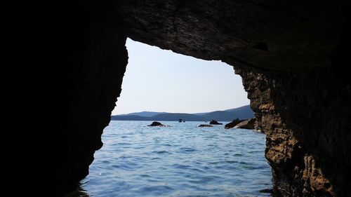 Scenic view of sea seen through cave