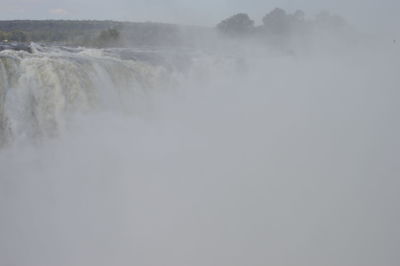 Scenic view of waterfall against sky