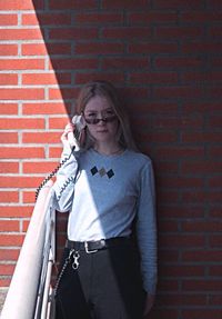 Portrait of woman standing against brick wall