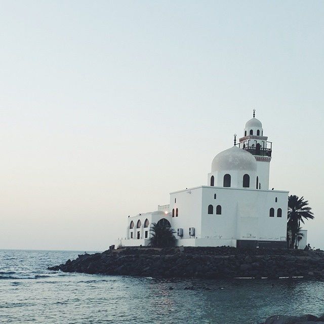 sea, architecture, built structure, water, building exterior, clear sky, horizon over water, copy space, waterfront, lighthouse, nature, outdoors, sky, day, religion, house, place of worship, tranquil scene, scenics, protection