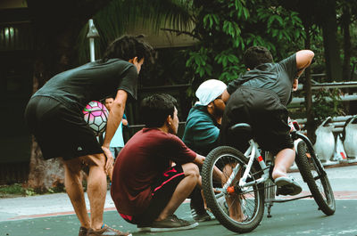 Rear view of people sitting on street