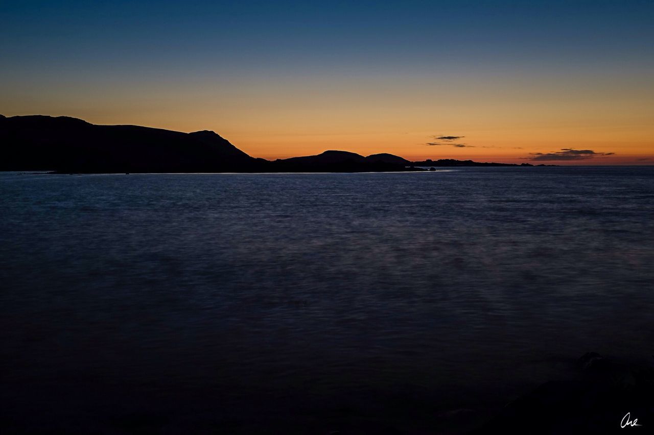 water, sunset, sea, scenics, tranquil scene, beauty in nature, tranquility, silhouette, mountain, idyllic, nature, clear sky, orange color, waterfront, sky, copy space, dusk, reflection, rippled, blue