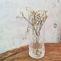 Close-up of vase on table against wall