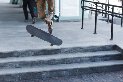 Low section of woman skateboarding on skateboard