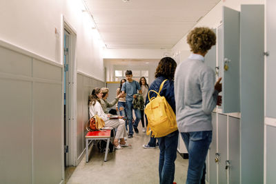 Multiracial group of teenage friends in school corridor