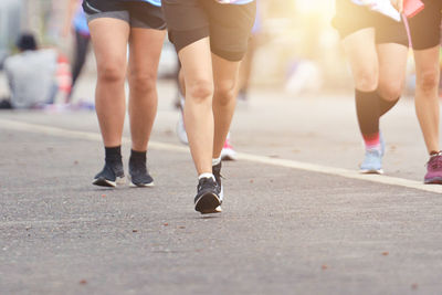 Low section of women walking on road