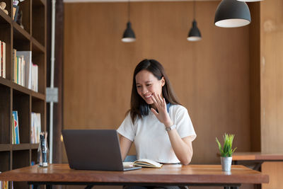 Businesswoman using laptop while sitting on table