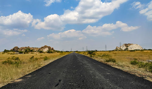 Road passing through landscape against sky