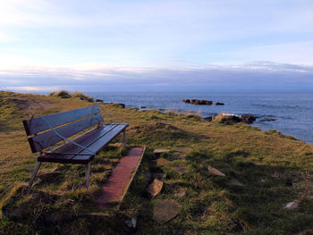 Empty bench by sea