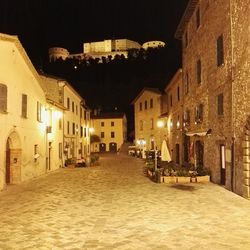 Illuminated town against sky at night