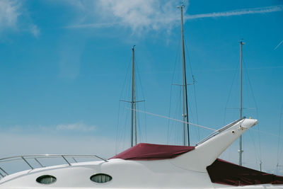 Close-up of boats moored against blue sky