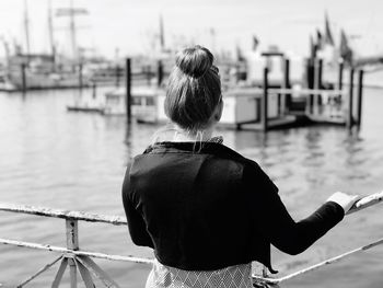 Rear view of woman sitting on boat in river