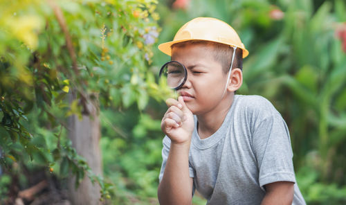 Boy looking away while standing outdoors