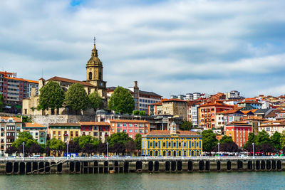 Buildings in city against cloudy sky