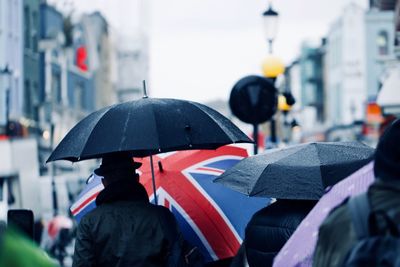 Man with umbrella on street during rainy season