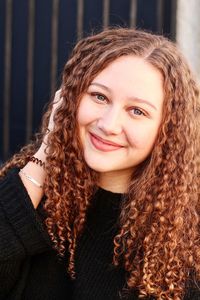 Portrait of smiling young woman with curly hair