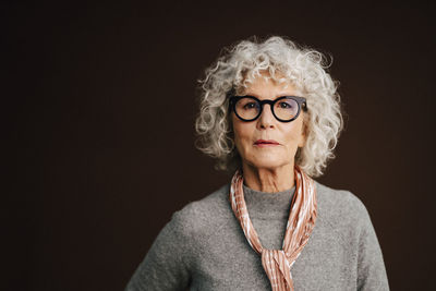 Portrait of confident elderly woman in studio