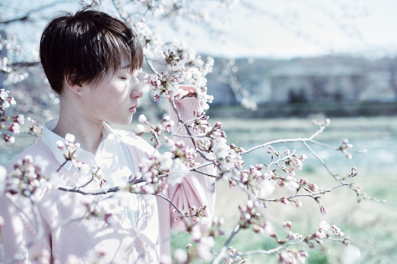 plant, flowering plant, flower, beauty in nature, freshness, nature, one person, fragility, real people, tree, growth, headshot, vulnerability, leisure activity, portrait, lifestyles, day, focus on foreground, young adult, outdoors, springtime, cherry blossom, flower head, contemplation