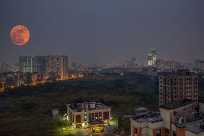 Illuminated cityscape against sky at night