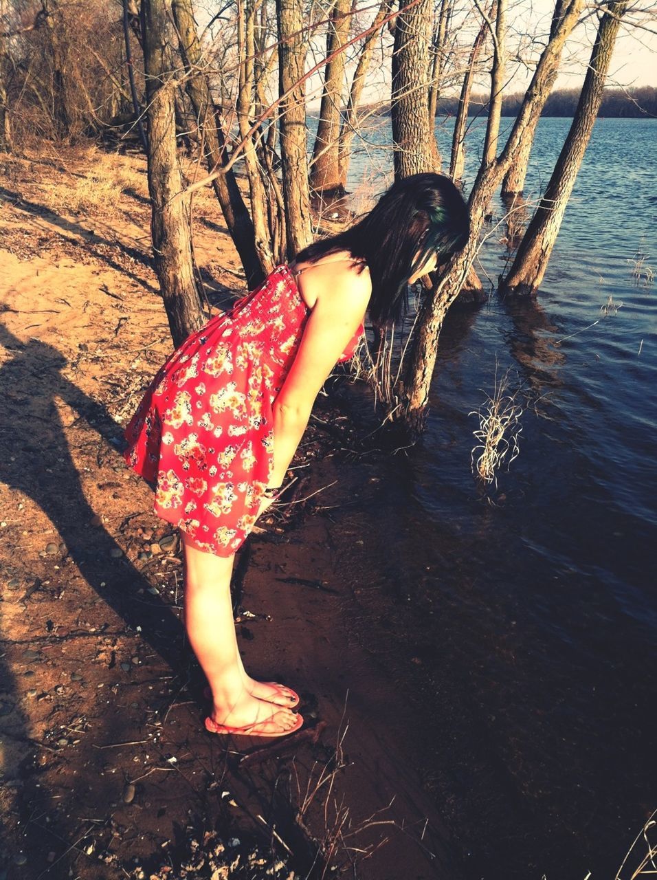 water, tree, leisure activity, lifestyles, tree trunk, person, lake, nature, outdoors, tranquility, standing, full length, beauty in nature, rippled, forest, low section, branch, day