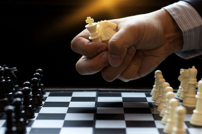 Cropped hand playing chess at home