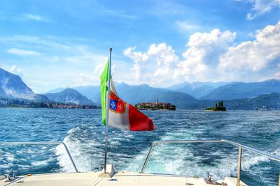 Boats in sea with mountain range in background