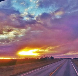 Road against cloudy sky at sunset