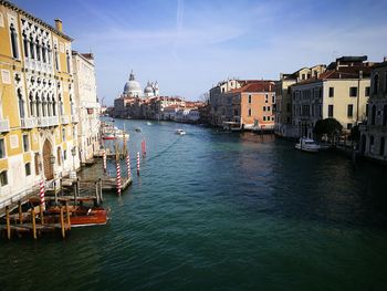Boats in canal amidst buildings in city