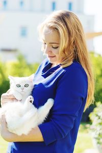 Close-up of young woman with cat standing at park