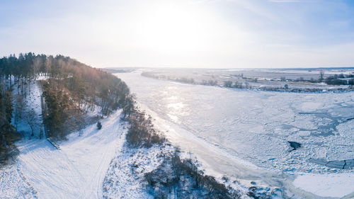 Scenic view of snow covered land against sky