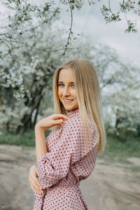 Young woman looking away while standing outdoors