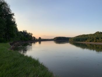 Scenic view of lake against clear sky during sunset