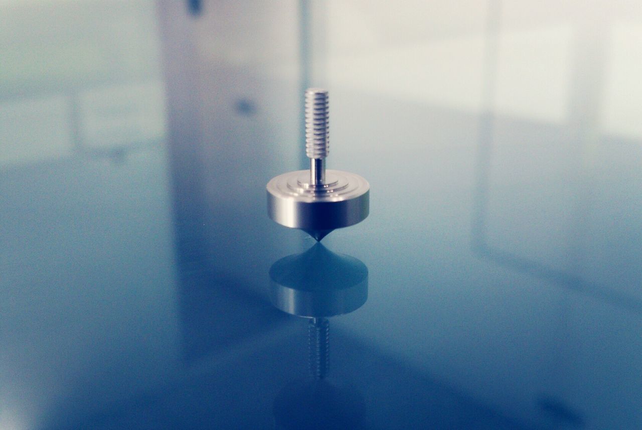 Close-up of metal spinning on glass table