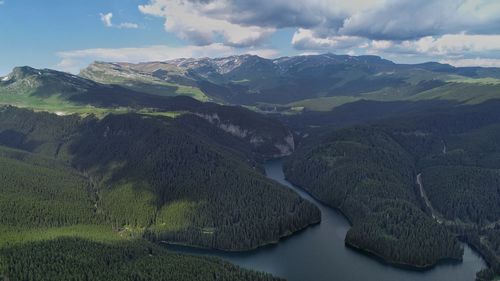 Scenic view of river amidst mountains against sky