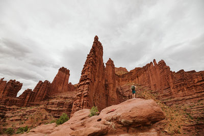 Male hiker looks up at the fisher towers near moab utah