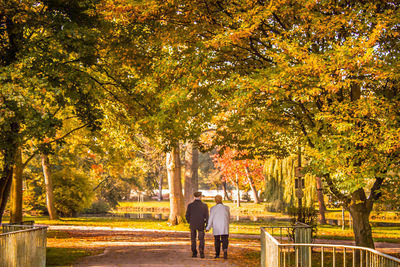 Rear view of woman walking on footpath