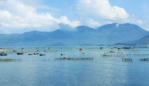 Scenic view of sea and mountains against sky