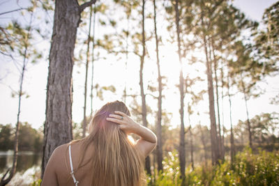 Woman standing by tree against sky