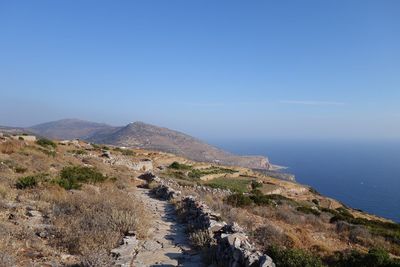 Scenic view of mountains by aegean sea against blue sky at sifnos