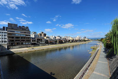 Canal amidst buildings in city against sky