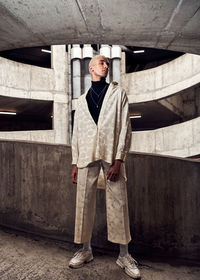 Portrait of young man standing against wall