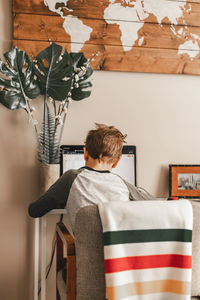 Rear view of boy studying at home