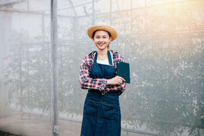 Young woman standing against wall