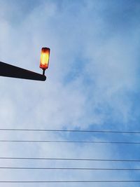 Low angle view of illuminated lighting equipment against sky