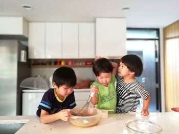 Brothers preparing food in kitchen