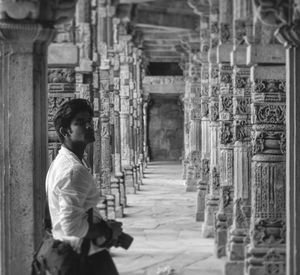 Side view of man standing in corridor of historic building