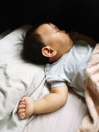 High angle view of baby lying on bed at home